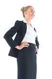 Low angle view of happy young businesswoman posing with hands on hips