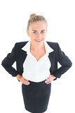 Amused young businesswoman posing with hands on hips