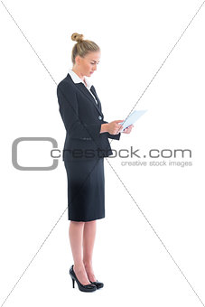 Side view of cute young businesswoman using her tablet