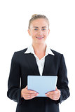 Front view of happy young businesswoman holding her tablet