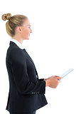Profile view of pretty blonde businesswoman holding her tablet