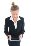 Front view of pretty blonde businesswoman working with her tablet