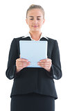 Low angle front view of smiling pretty businesswoman using her tablet