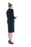 Rear view of chic young businesswoman holding her tablet