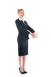Cheerful smart businesswoman presenting a piggy bank