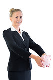 Attractive young businesswoman holding a piggy bank