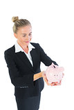 Beautiful modern businesswoman holding a piggy bank