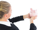 Blonde cute businesswoman holding a piggy bank