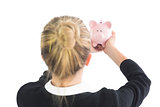 Blonde young cute businesswoman holding a piggy bank