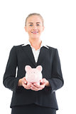 Happy young businesswoman holding a piggy bank