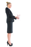 Side view of blonde cute businesswoman holding a piggy bank