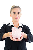 Gorgeous young businesswoman holding a piggy bank