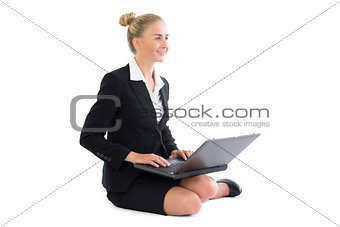 Amused businesswoman making use of her notebook