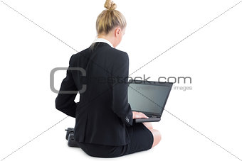Calm pretty businesswoman sitting on floor using her laptop