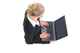 Cute blonde businesswoman making use of her laptop