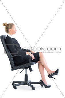 Side view of attractive serious businesswoman sitting on an office chair