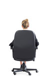 Rear view of blonde well dressed businesswoman sitting on an office chair