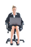 Beautiful businesswoman sitting on an office chair using her notebook
