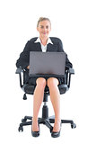 Lovely chic businesswoman sitting on an office chair working with her notebook
