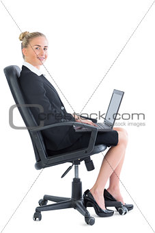Side view of cute blonde businesswoman sitting on an office chair