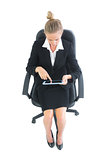 Concentrated young businesswoman sitting on her office chair