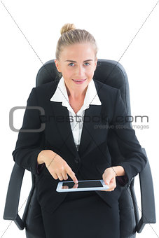 Smiling blonde businesswoman sitting on her office chair