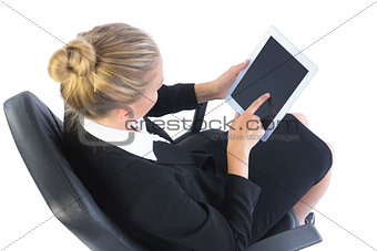 Busy businesswoman sitting on an office chair using her tablet