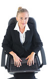 Cute young businesswoman sitting on an office chair using her notebook