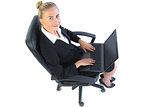 Cute businesswoman sitting on her office chair using her notebook