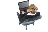 Rear view of blonde businesswoman sitting in swivel chair using laptop
