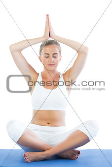 Toned calm blonde sitting in lotus pose meditating