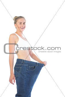 Confident smiling blonde wearing too big trousers