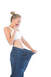 Confident laughing blonde wearing too big trousers