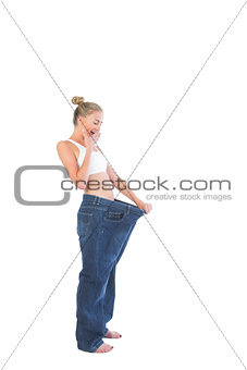 Confident amazed blonde wearing too big trousers