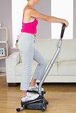 Side view of sporty woman training on step machine