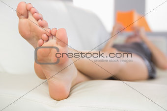 Close up picture of feet from woman lying on couch