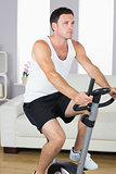 Attractive sporty man exercising on bike