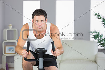 Handsome sporty man exercising on bike