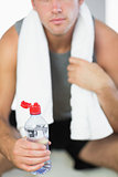 Close up of water bottle held by sporty man