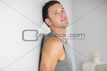 Sporty handsome man leaning against wall