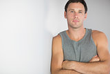 Sporty handsome man leaning against wall with arms crossed