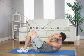 Handsome sporty man doing sit ups