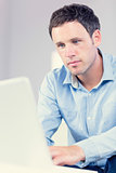 Attractive casual man looking at laptop