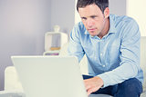 Content casual man looking at laptop