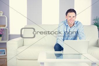 Smiling casual man using laptop