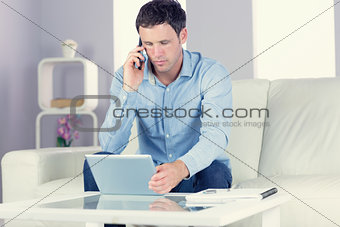 Content casual man using tablet and phoning