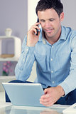 Happy casual man using tablet and phoning