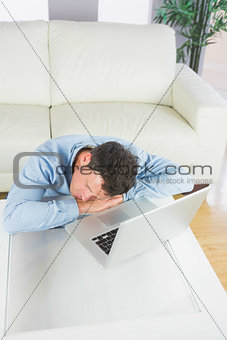 Attractive casual man sleeping with head resting on table