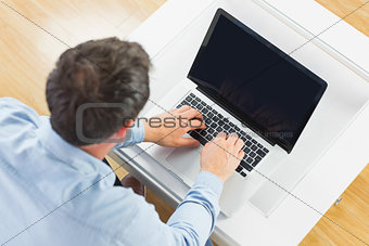 High angle view of casual man using laptop