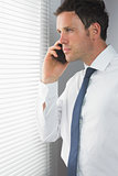 Serious handsome businessman phoning
